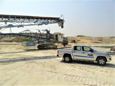 FAM truck next to machinery in open pit