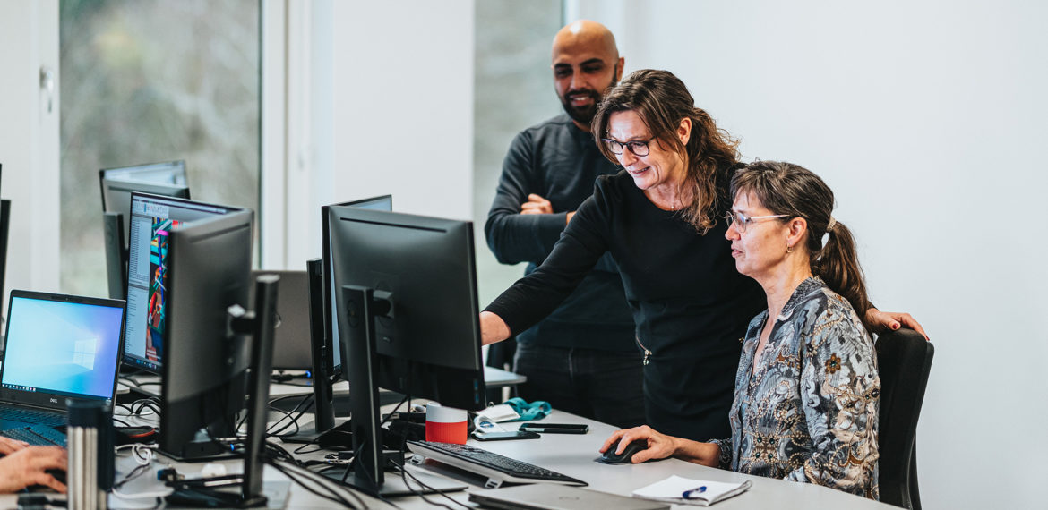 Three employees from denmark in front of computer - working culture at BEUMER Group